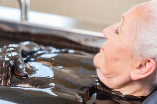 Femme âgée dans un bain de boue