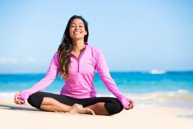 une femme en méditation sur la plage pendant sa cure émotionnelle