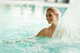 une femme profitant d'un jet d'eau dans la piscine d'un hôtel de cure en Allemagne