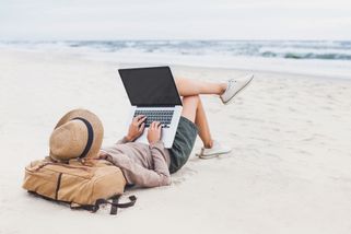 personne allongée sur la plage avec un ordinateur portable