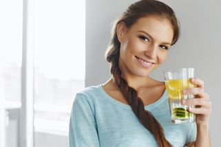 Une femme souriante avec un verre d'eau