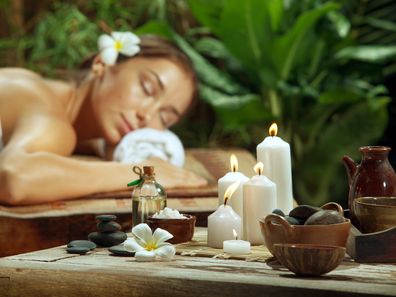 Une femme se détend sur une table de massage dans la verdure.