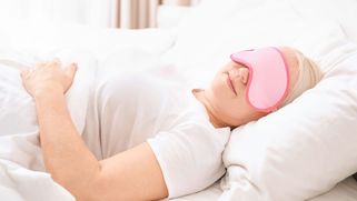 Une femme se reposant dans unFemme se reposant dans un lit avec un cache yeuxlit