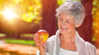 Femme âgée regardant une pomme